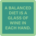 The Balanced Diet Coaster by Drinks On Me features the quote "A balanced diet is a glass of wine in each hand." Its green, playful design makes it an ideal bar cart accessory or a fun housewarming gift.