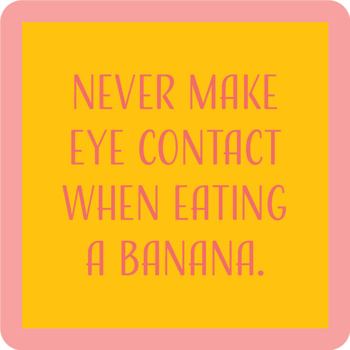 The Banana Coaster by Drinks On Me features a yellow square with a pink border and pink text: "Never make eye contact when eating a banana." A hilarious gift for housewarmings or quirky bar cart accessories.