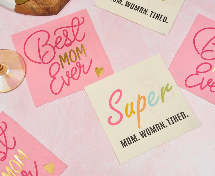 Sugarplum’s Best Mom Ever Cocktail Napkins (26pk) feature “Best Mom Ever” and “Super MOM. WOMAN. TIRED.” designs—perfect party supplies for Mother’s Day or as cocktail napkins, with gold heart and glass accents for a festive look.