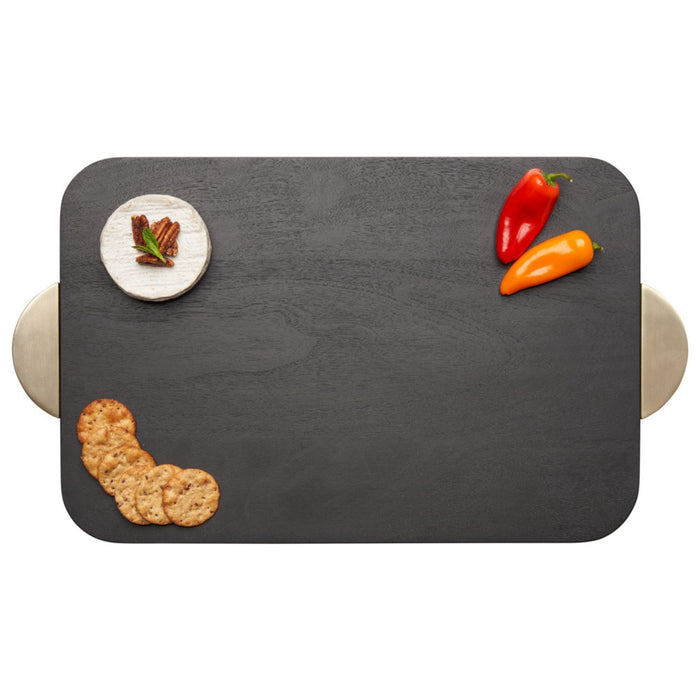 The Maple Black Acacia Wood Cutting + Cheeseboard w/ Gold Handles (18 x 12") holds a small round cheese, red and orange mini sweet peppers, and four crackers—ideal as an engraved board for stylish entertaining.