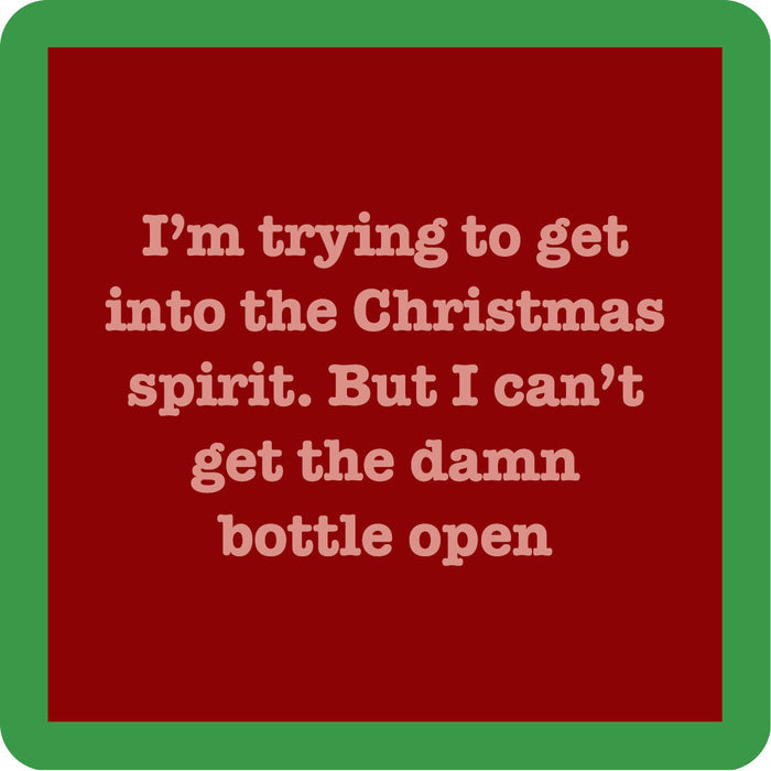 A red square coaster from Drinks On Me features beige text: “I’m trying to get into the Christmas spirit. But I can’t get the damn bottle open”—a funny Bottle Open Coaster for your bar cart or as a cheerful drink accessory.