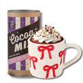 The Bow Mug + Hot Cocoa Gift Set by Sophistiplate LLC features a festive mug filled with hot chocolate, topped with whipped cream and chocolate shavings.
