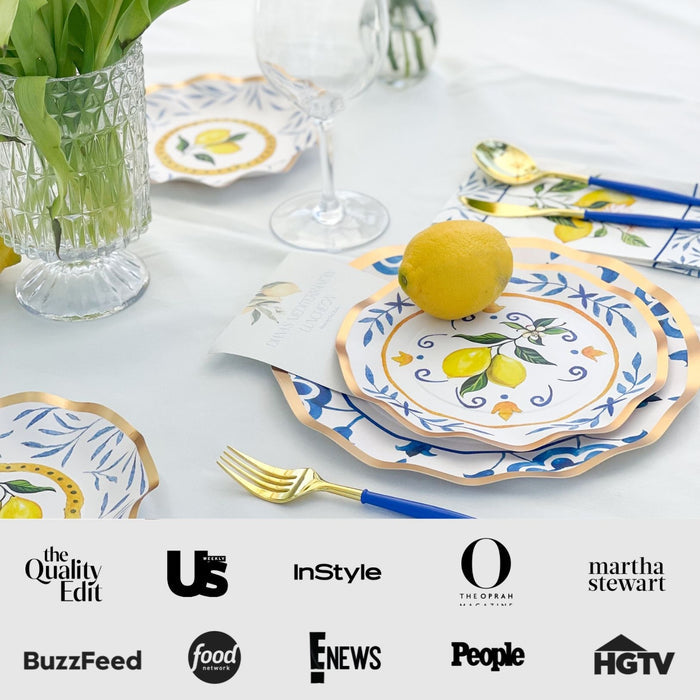 The Capri Coast Table Setting by Sophistiplate LLC features lemon-themed heavy duty plates, blue and gold cutlery, a glass, a vase with green leaves, and a fresh lemon on a plate. BuzzFeed, People, and HGTV logos appear below.