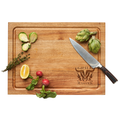 A Maple Carv'd Acacia Carving Board (15x20") engraved with GRILL MASTER 710 holds Brussels sprouts, artichoke, thyme, lemon wedge, radishes, and includes a 13" German steel chef's knife.