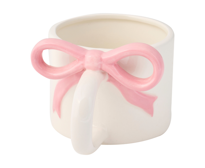 The Sophistiplate Ceramic Pink Bow on Handle Mug, 12oz, features a plain white design with a charming pink bow-shaped handle for a playful yet functional touch.