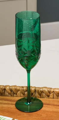The Sophistiplate Champagne Classic in green (8.9 oz), a patterned, shatterproof, BPA-free plastic flute, stands on a wooden tray with a woven border against a white background.