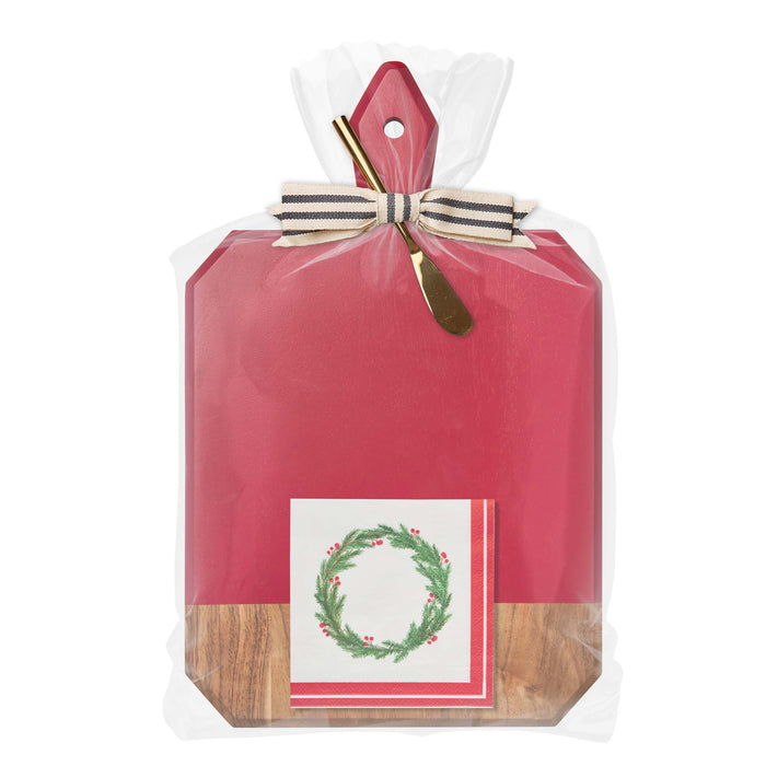 The Sophistiplate Christmas Board Gift Kit: Merry & Bright features a red and acacia wood charcuterie board, gold cheese spreader, holiday wreath napkins, and festive ribbon—perfect for gifting this season.