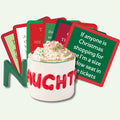 A white mug with "NAUGHTY" in red holds whipped cream with sprinkles. Behind it are red and green coasters from the Drinks On Me Christmas Coaster Bundle: Version 2, including one with a funny holiday travel quote—ideal hostess gifts or stocking stuffers.