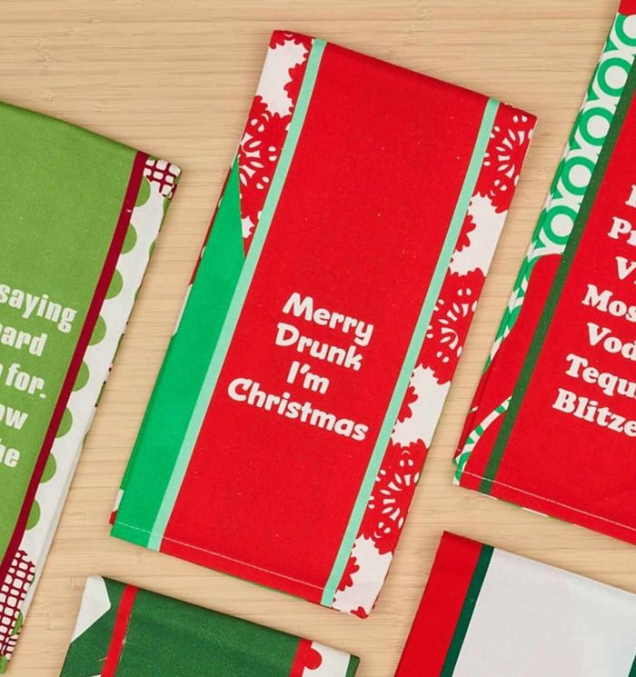 The CHRISTMAS Merry Drunk Dish Towel by Drinks On Me features festive red, green, and white hues with the quote “Merry Drunk I’m Christmas”—a humorous kitchen gift or fun addition to your holiday decor.