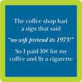 The Cigarette Coaster by Drinks On Me features a blue sign with a green border that says, “No wifi pretend its 1973!” Ideal as a funny drink coaster or retro bar cart accessory for hostess gifts.