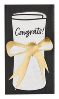 A white rolled-up diploma reading "Congrats!", tied with a metallic gold bow on a black background—perfect for celebrating with Sophistiplate Classic Grad Guest Towels/20pk.