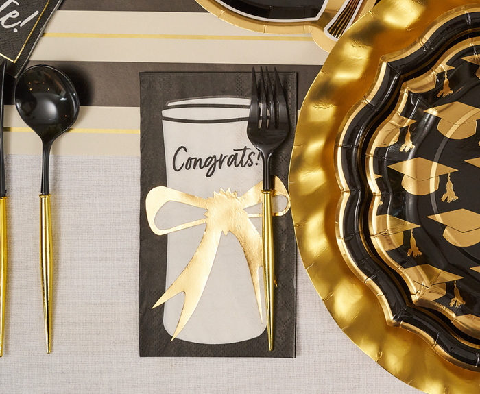 Celebrate your graduation with the Sophistiplate Classic Grad Table Setting—designer gold & black plates with grad caps, gold utensils, and a Congrats! napkin with a gold bow. Perfect disposable party supplies for your special day.