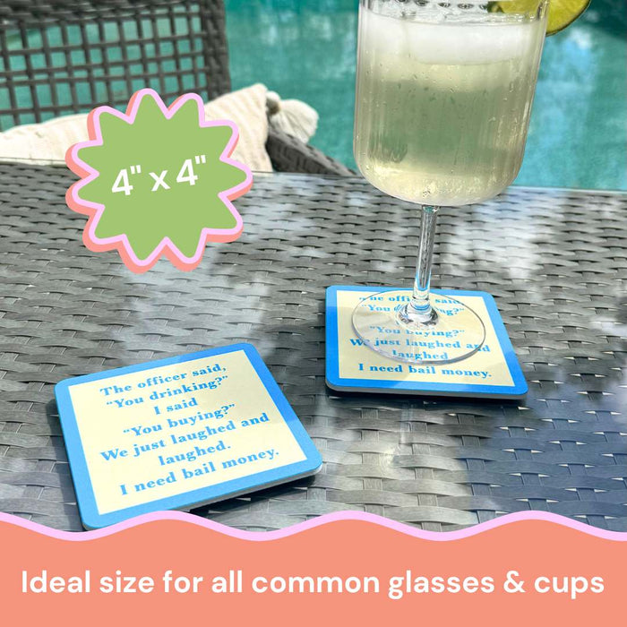 A glass with a lime slice rests on a blue and white Drinks On Me "Coaster Bundle: Best Friends" coaster featuring funny text, atop a wicker table; another coaster is beside it. Sized 4” x 4”, ideal for all common glasses & cups.