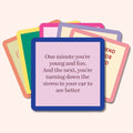 A stack of colorful, funny coasters from Drinks On Me’s Coaster Bundle: Best Sellers sits on top; the first reads, “One minute you’re young and fun. The next, you’re turning down the stereo to see better”—a quirky party gift.