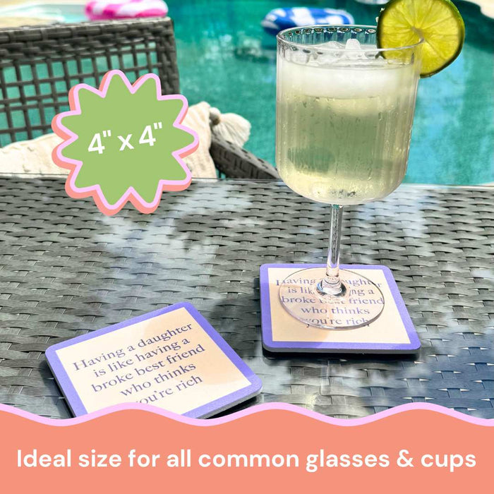 A glass of sparkling drink with lime sits on a Drinks On Me Coaster Bundle: Parenting beside the pool. A second coaster is nearby, both with funny sayings about daughters. This 4x4 bundle fits most glasses and makes a perfect gift for friends.