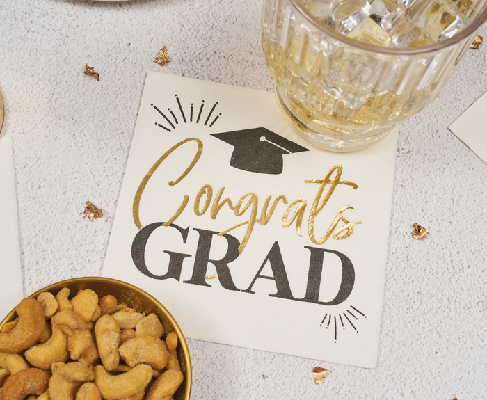 Sugarplum Congrats Grad Cocktail Napkins (26pk), featuring gold and black lettering, are perfect for graduation celebrations—ideal next to your drinks and snacks.