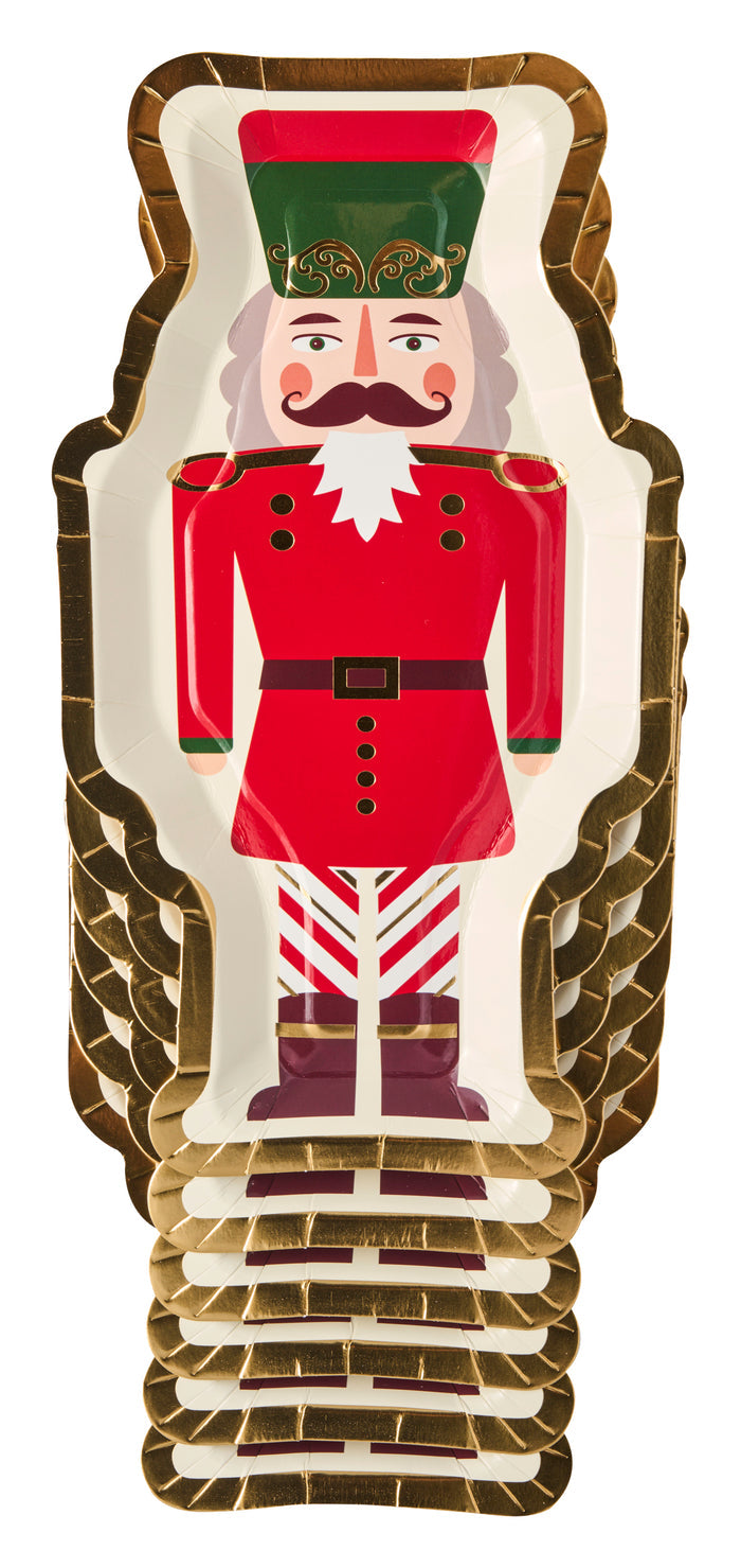 The Sugarplum Cookie Tray Gifting Kit Nutcracker/6pkg features decorative plates shaped like a Nutcracker soldier, with red uniform, green hat, striped pants, and gold trim—ideal as a Christmas cookie tray for your holiday treat exchange.