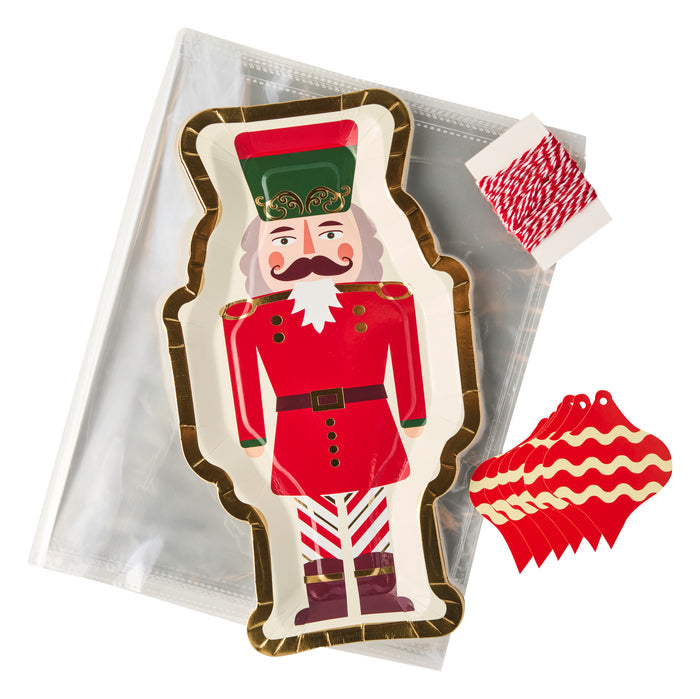 The Sugarplum Cookie Tray Gifting Kit Nutcracker/6pkg includes a nutcracker-shaped tray with red and gold design, string, tags, and a clear pouch—ideal for holiday treat exchanges.
