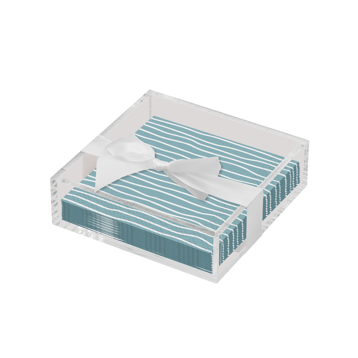 The Sophistiplate Eco Cocktail Napkin with Napkin Tray features blue and white striped napkins tied with a white ribbon, displayed in a clear tray—perfect for adding modern style to your tabletop.
