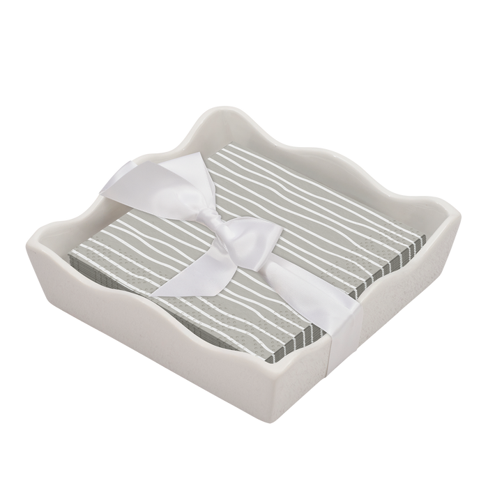 The Sophistiplate Eco Cocktail Napkin with Napkin Tray offers a stylish, eco-friendly alternative to an acrylic napkin tray. Gray and white striped napkins in a white ceramic tray add elegance to any modern table setting.
