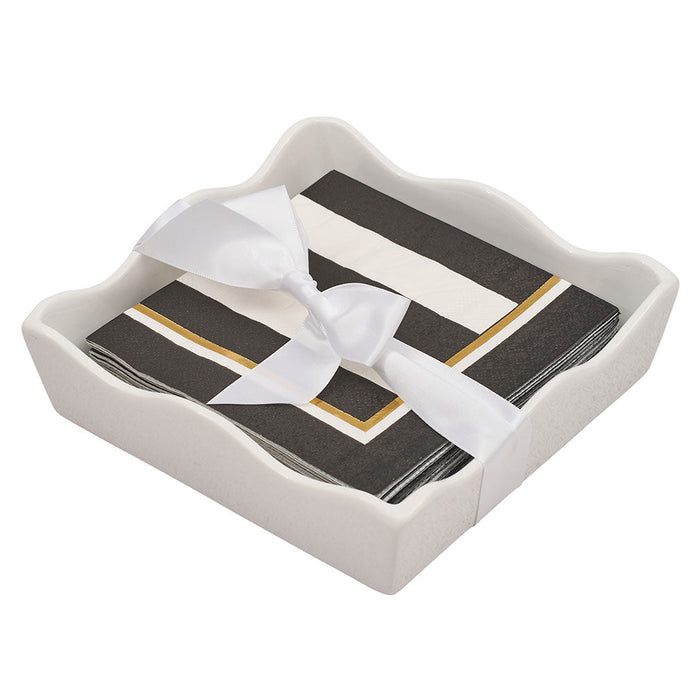 The Sophistiplate Everyday Cocktail Napkin with Napkin Tray features a wavy ceramic holder displaying stylish cocktail napkins in black, white, and gold stripes, neatly tied with a white satin ribbon.