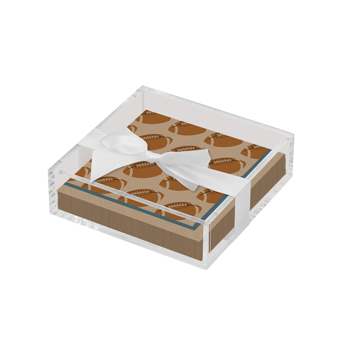 The Sophistiplate Everyday Cocktail Napkin with Napkin Tray features a clear acrylic holder displaying football-patterned brown napkins, neatly tied with a white ribbon bow.