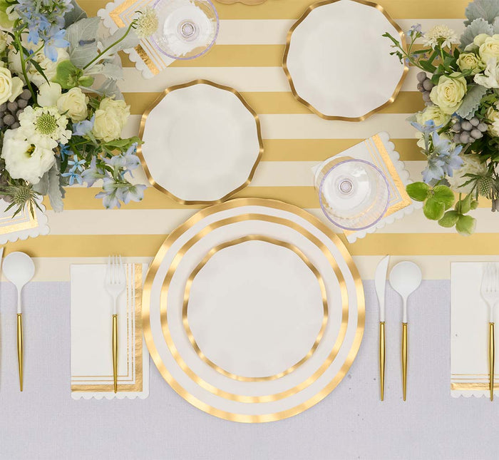 Create a stylish tablescape with the Everyday White Table Setting by Sophistiplate LLC, featuring designer gold-and-white striped plates, gold cutlery, white napkins, and coordinating decor—bringing a party-in-a-box right to your table.