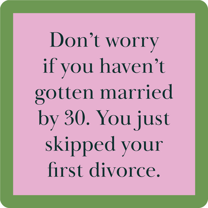 The First Divorce Coaster by Drinks On Me features black text on a pink square with a green border: "Don’t worry if you haven’t gotten married by 30. You just skipped your first divorce." Perfect as a housewarming gift or for your bar cart.