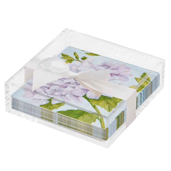 The Sophistiplate Floral Cocktail Napkin with Napkin Tray features floral-patterned napkins with purple hydrangeas and green leaves in a clear tray—ideal for modern tabletops.