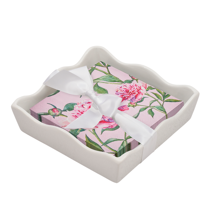 The Sophistiplate Floral Cocktail Napkin with Napkin Tray features pink florals and green leaves, tied with a white ribbon and set in a wavy-edged white ceramic tray—an elegant touch for any modern table.