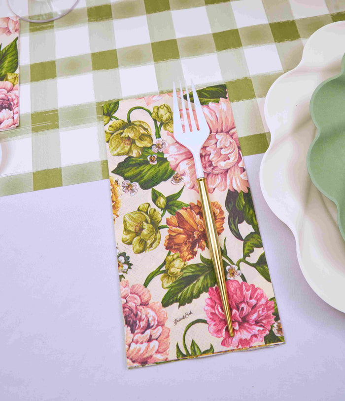The Garden Rose Table Setting by Sophistiplate features a gold and white fork on a floral napkin, placed atop a green and white checkered tablecloth with scalloped designer disposable plates in coordinating colors.