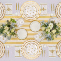 A tabletop set featuring Sophistiplate Honeybee Salad Plates (8pk), gold-striped paper plates with ruffled edges, bee-themed napkins, matching cups, and floral centerpieces, all elegantly displayed on a yellow and white striped table runner.