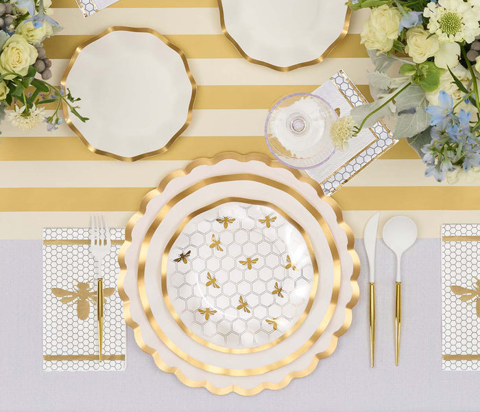 Create a refined table presentation using Sophistiplate’s Honeybee Salad Plates (8pk), adorned with graceful gold-striped accents and accented by ruffled edges. Gold utensils, fresh flowers, and a wine glass rest atop a light tablecloth, while the plates and coordinating napkins feature enchanting honeycomb and bee motifs, infusing whimsical charm into the sophisticated décor.