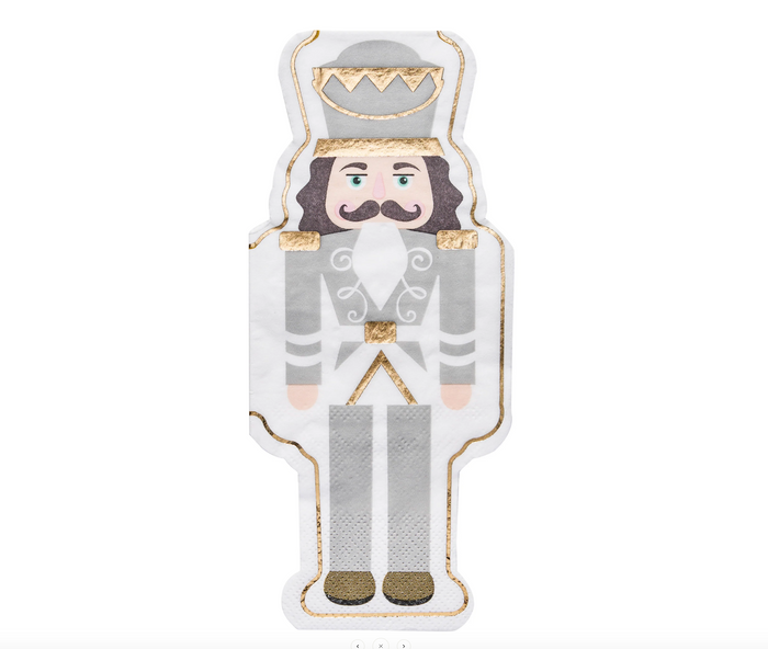 A guest towel by Sophistiplate, inspired by the Gilded Nutcracker napkins, features a nutcracker soldier in a gray uniform with gold accents and tall hat on a white background. Sold as "Gilded Nutcracker Guest Towel/16 pkg.
