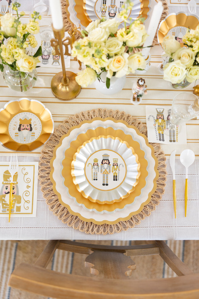 Create an elegant holiday table setting with Sophistiplate’s Gilded Nutcracker Dinner Plates (8pk), featuring delightful nutcracker artwork. Pair these plates with gold utensils, crisp white napkins, glowing candles, and arrangements of pale yellow and white flowers atop a striped tablecloth—an inviting way to showcase your favorite festive tableware.