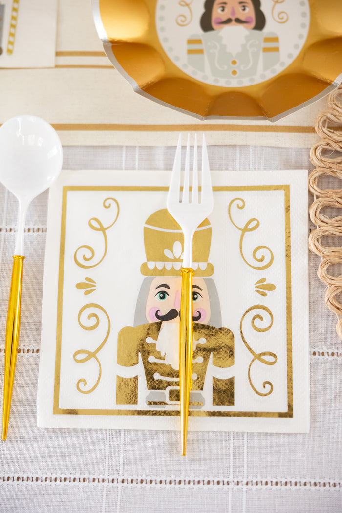 The Sophistiplate Gilded Nutcracker Paper Lunch Napkin (20pk) features a gold nutcracker design, bringing festive flair to your holiday table when paired with gold-handled cutlery and a gold-edged plate.