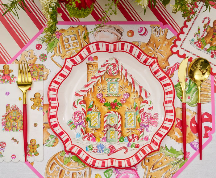 Create a festive Christmas tablescape with the "Gingerbread: Christmas Table for 8" set—includes designer disposable plates with a gingerbread house design, red-and-white stripes, gold cutlery, themed placemats, napkins, and tablecloth.