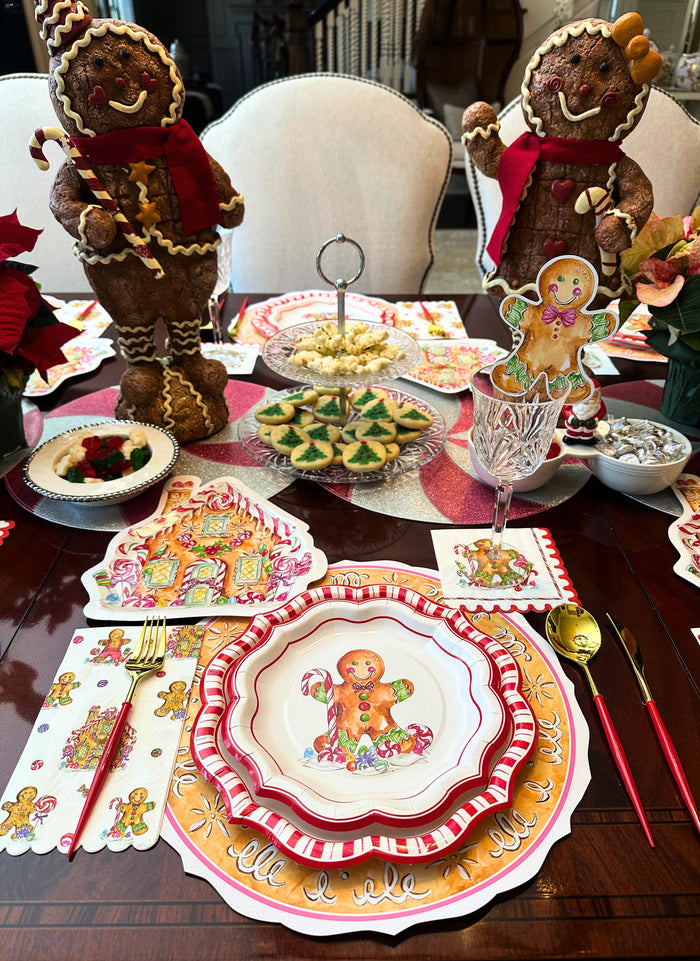 Create a festive holiday table with Sophistiplate’s Gingerbread Table Setting, featuring disposable plates, placemats, and napkins, plus two large gingerbread centerpieces surrounded by cookies, treats, and holiday décor.