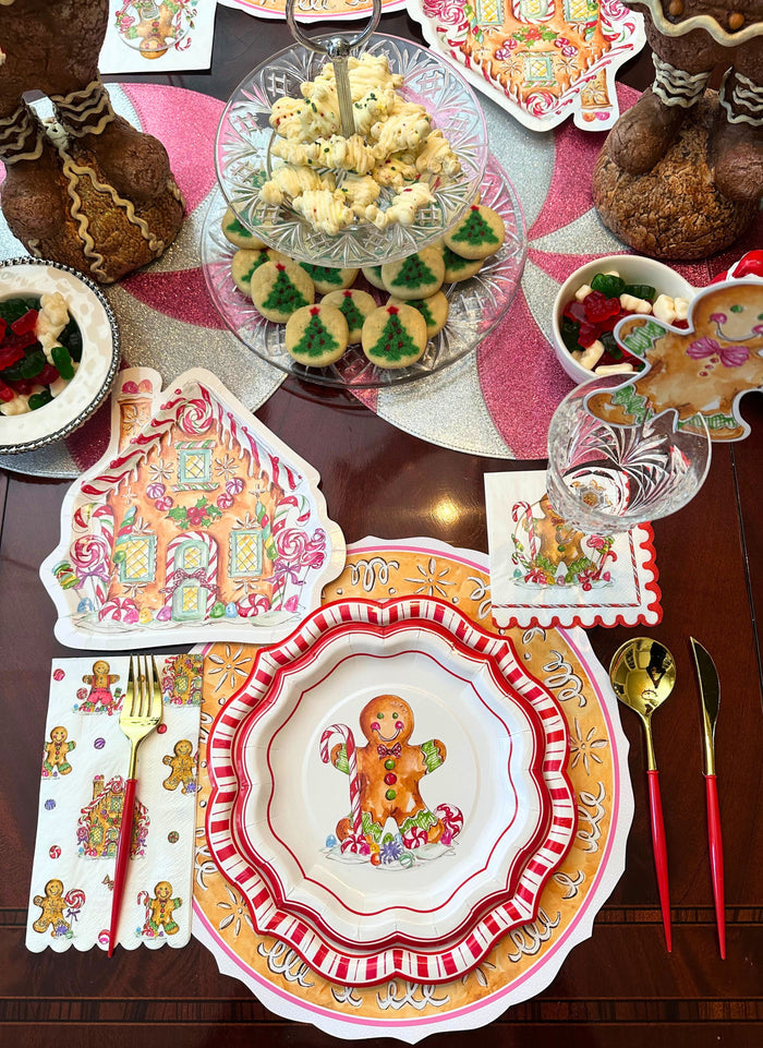 Create a cheerful Christmas atmosphere with the Sophistiplate Gingerbread Table Setting, featuring festive plates, napkins, decorations, and gold cutlery with red handles—perfect for your holiday party table.