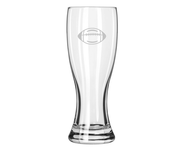 Enjoy your favorite brew in style with the Maple Glass Grand Pilsner | Football | 20oz—a tall, clear beer glass featuring an etched football on top, a smooth curved design, and a slightly flared base.