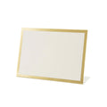 The Hester & Cook Gold Frame Place Card (12ct) stands upright on a white surface at a slight angle, featuring a blank white card with an elegant gold border—ideal for buffet labels or place cards.
