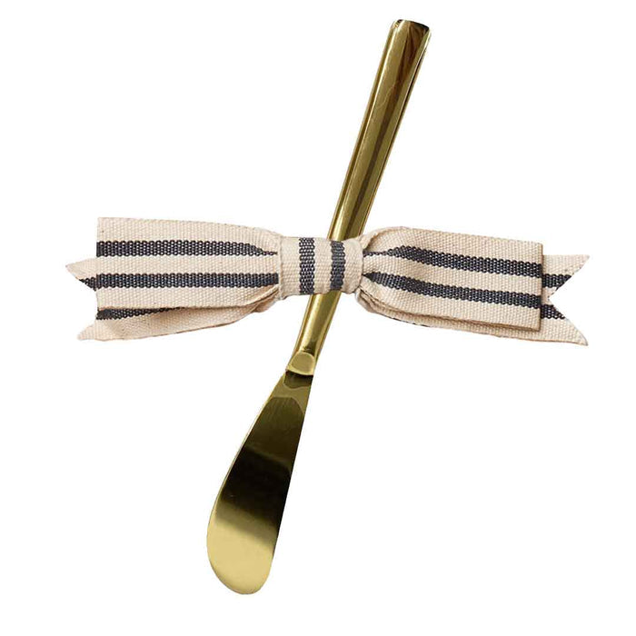 The Gold Spreader Knife & Ribbon by Sophistiplate features a gold butter spreader adorned with a striped beige and black bow around the handle, shown on a white background.
