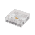 The Sophistiplate Golden Apple Cocktail Napkins with Acrylic Tray features stylish white and silver napkins neatly arranged in a clear acrylic tray, elegantly finished with a white ribbon bow and a gold accent—an exquisite addition to any modern tabletop décor.