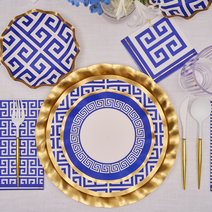 The Greek Key Table Setting by Sophistiplate LLC includes designer disposable plates with a gold and blue Greek key pattern, gold utensils, matching napkins, and a clear cup—ideal for your next party-in-a-box celebration.