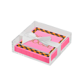 The Sophistiplate Halloween Cocktail Napkin with Napkin Tray features pink napkins with a black and orange checkered border, elegant gold writing, and comes in a clear acrylic tray tied with a white ribbon—perfect for modern tabletop decor.