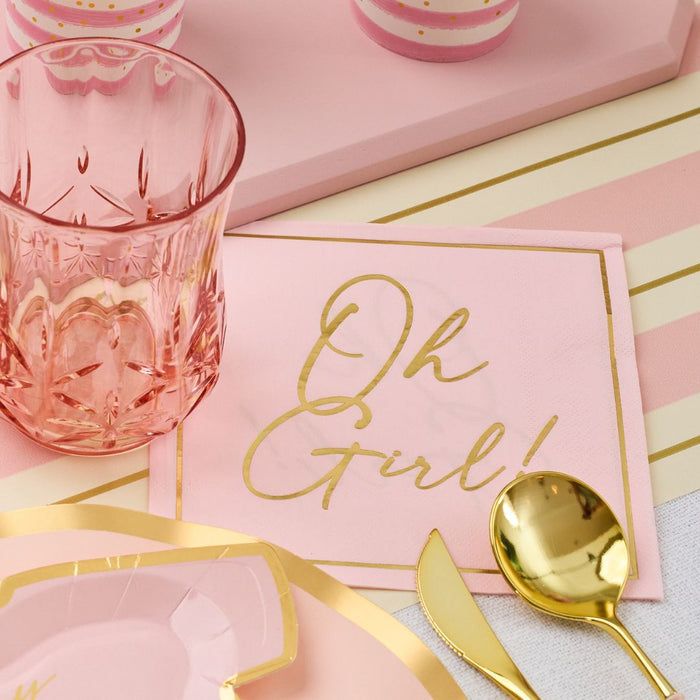 The Hey Baby Blush Table Setting by Sophistiplate LLC features a pink napkin with “Oh Girl!” in gold script, a pink glass, gold spoon, and durable paper plates—perfect for your chic party-in-a-box celebration.