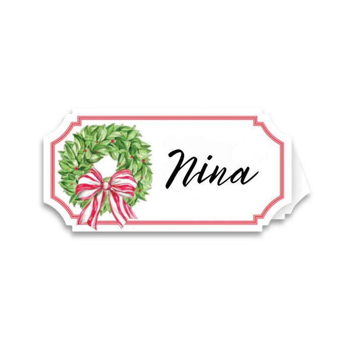 The Rosanne Beck Holly Wreath Place Card (10pk) features a white card with a red border, a green wreath with red and white bow on the left, and space for names—ideal as buffet labels or place cards.