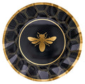 The Sophistiplate Honeybee Dinner Plates (8pk) feature a round black design with a gold honeycomb pattern, a gold bee illustration in the center, and an elegant gold rim—perfect for bringing sophisticated charm to any celebration.