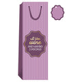 The Drinks On Me “I Like Wine” wine bag is tall with pink-purple stripes, a dark handle, and a funny gold and white label. Includes a matching blank gift tag—perfect hostess gift!.