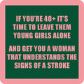The If You're 40 Coaster by Drinks On Me features a green background, pink border, and pink text: "If you’re 40+, it’s time to leave them young girls alone and get you a woman that understands the signs of a stroke." A funny coaster and perfect housewarming gift!.